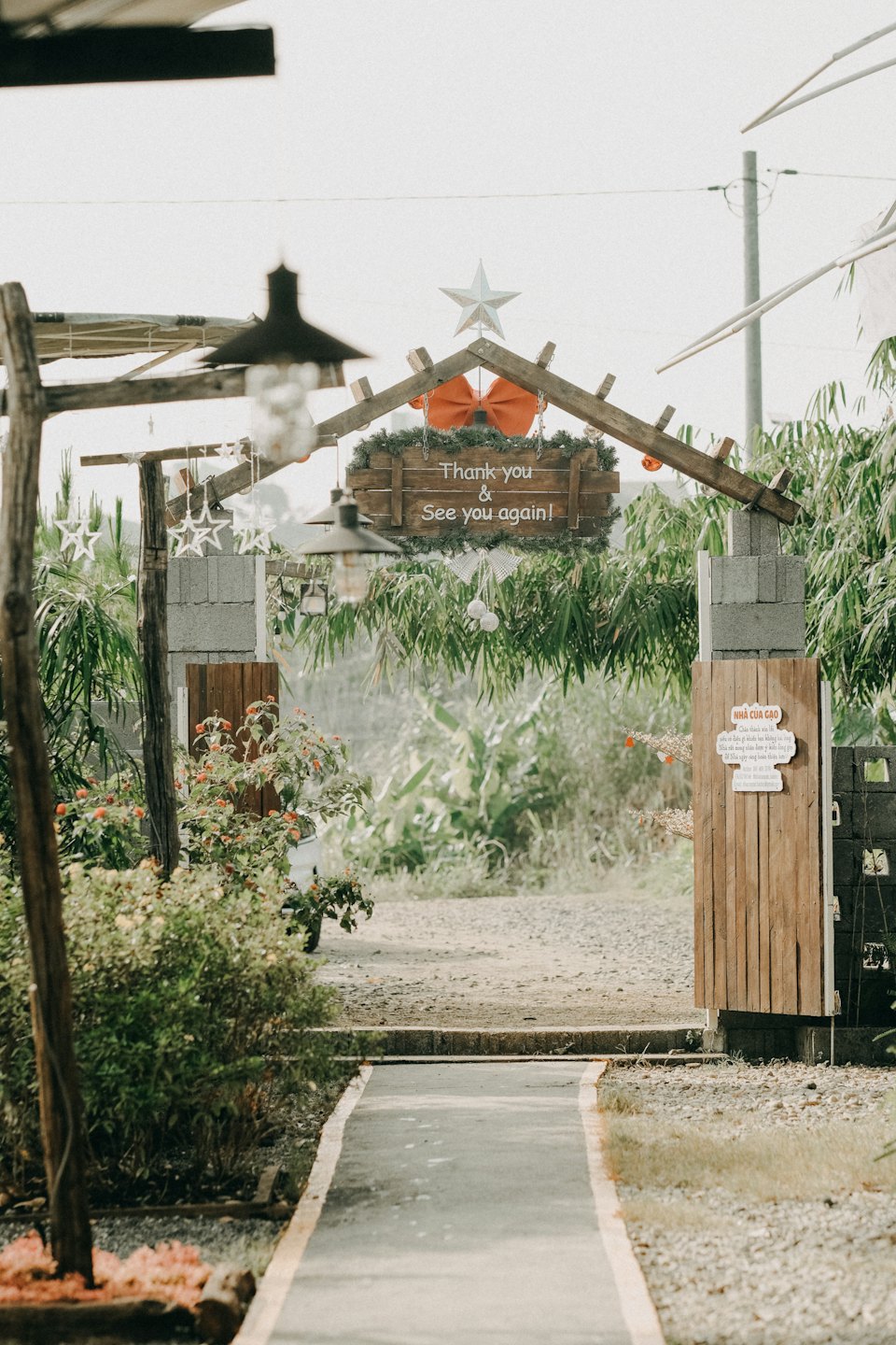 Arco di legno con decorazioni stagionali che conduce a un sentiero del giardino.
