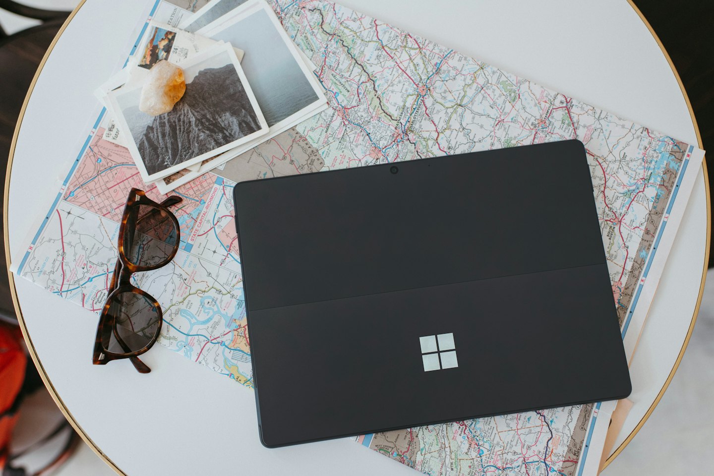 Computer portatile e oggetti da viaggio disposti su una mappa per pianificare un viaggio.